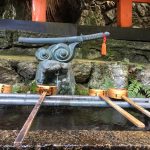 hand washing station with a statue of a sword at small shrine at Fushimi Inari Shrine